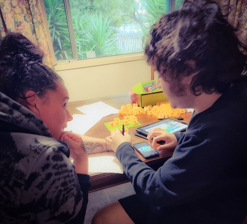 Carer with disabled boy using phone