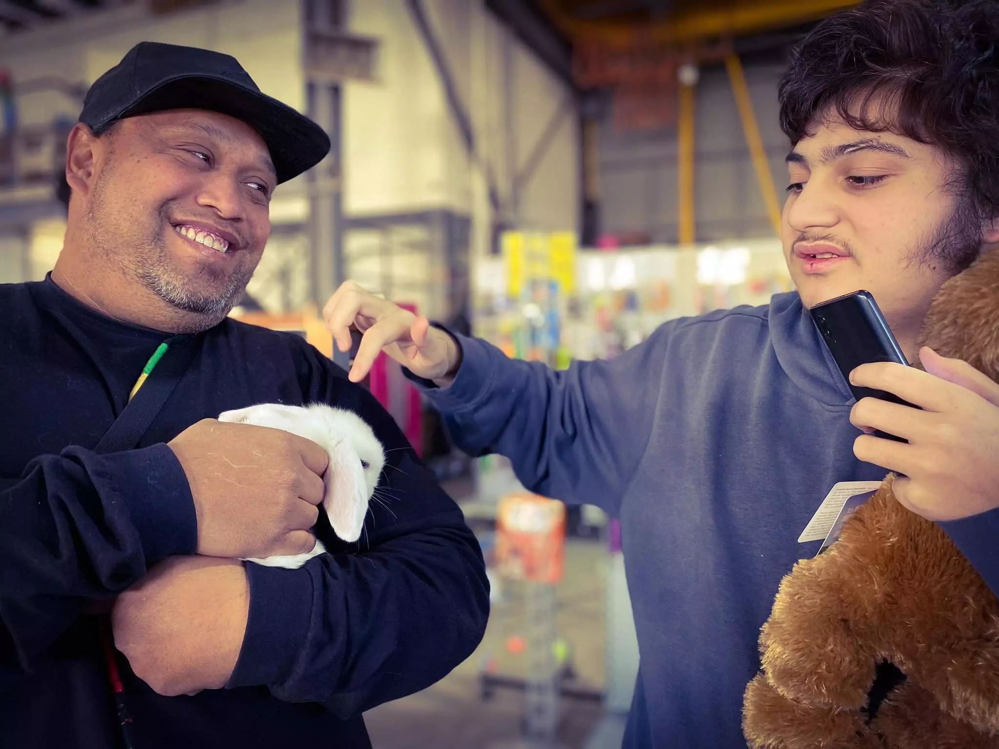 Man with disabled man patting bunny rabbits